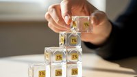 Business professional stacking transparent cubes with percentage symbols building pyramid structure representing growth strategy and financial planning concepts.