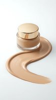 Luxury foundation jar with golden cap and creamy beige makeup smear on white background. Premium cosmetic product for beauty and skincare advertising.