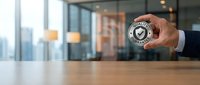 Businessman holding certified quality badge with checkmark symbol in modern office environment with city skyline view, representing trust and approval.