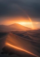 Dramatic sunset over sand dunes creates golden light rays piercing through dark storm clouds, illuminating rolling desert landscape with warm orange glow and mountain silhouette.