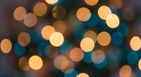 Abstract bokeh lights background with warm golden and cool blue circular blur effects creating dreamy atmosphere for holiday celebrations and festive designs.