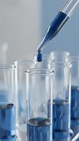 Laboratory pipette dropping blue liquid into test tube for scientific research and chemical analysis experiments.