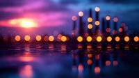 Glowing orange lights reflected on water surface against dramatic purple and blue sunset sky, creating magical bokeh effect and dreamy atmosphere.