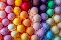 Colorful ice cream scoops in rainbow arrangement creating vibrant pattern of frozen dessert flavors, overhead view showing texture and variety of gelato colors.