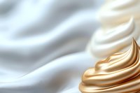 Luxurious white and gold cream swirls in smooth flowing waves create elegant abstract background texture with soft gradient lighting effects.