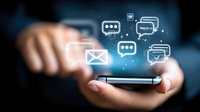 Glowing social media and messaging icons floating above smartphone screen with hands holding device, representing digital communication technology.