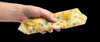 Hand holding a beeswax food wrap with colorful honeycomb pattern, isolated on transparent background. Great for eco, kitchen, and sustainability clipart, stickers, and print on demand.