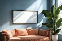 Minimalist living room with coral sofa, blank wooden frame mockup on blue wall, tropical plant and natural window light creating shadow patterns.