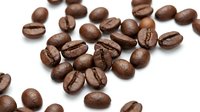 Roasted coffee beans scattered on white background, isolated for beverage, food and cafe design projects.