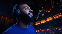 Young African American man wearing headphones in dark atmospheric setting with bokeh lights, expressing joy while listening to music in vibrant nightclub environment.