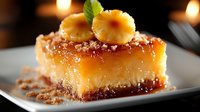 Layered dessert with golden sponge cake, caramel sauce, and candied fruit garnish on white plate with warm bokeh lighting in background. Perfect for bakery, restaurant, and food photography needs.