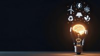 Glowing light bulb with brain filament surrounded by floating renewable energy icons on dark background for innovation and sustainability concepts.