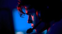 Dramatic profile of young man illuminated by contrasting red and blue neon lights, creating moody atmosphere for nightlife, music, or cyberpunk themes.