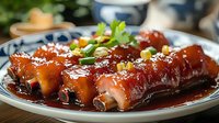 Glazed pork ribs in sweet and savory Asian sauce garnished with fresh herbs and sesame seeds served on traditional blue and white porcelain plate.