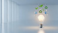 Glowing light bulb with green eco symbols floating above in modern white corridor representing sustainable energy innovation and environmental technology solutions.