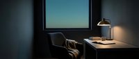 Minimalist workspace with desk, chair, and lamp beside window overlooking clear sky at dusk, suitable for office, productivity, and remote work concepts.