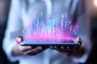 Glowing holographic city skyline emerging from digital tablet with vibrant pink and blue light streams, held by hands in business setting. Modern technology concept.