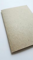 Blank recycled cardboard sheet with natural texture and visible fibers, isolated on white background, ready for design, printing, packaging, and branding projects.