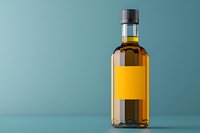 Glass bottle with golden liquid and blank label on turquoise background, minimalist product photography setup for branding and packaging design.