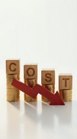 Wooden blocks spelling COST on golden coin stacks with red downward arrow showing financial decline and expense reduction concept.