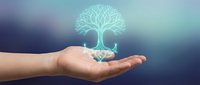 Human hand holding glowing tree hologram with roots on blurred gradient background symbolizing growth, environmental protection and sustainability concepts.