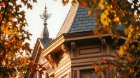 Victorian house architectural details with ornate decorative elements and autumn foliage framing the scene during golden hour lighting.