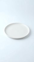 Empty white ceramic plate isolated on white background for food presentation and culinary design projects.