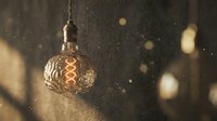 Vintage Edison bulb with decorative filament glowing warmly against dark textured background with golden bokeh lights creating cozy atmospheric lighting.