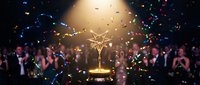 Golden trophy award ceremony with confetti and applause from formal audience. Corporate recognition event with star-shaped prize and celebration atmosphere.