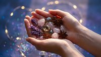 Cupped hands holding aromatic spices including star anise, cinnamon, and cardamom pods against bokeh lights background for culinary and cooking concepts.