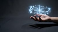 Musician hand holding glowing musical notes and treble clef symbols for music production, composition, streaming services, education, and entertainment industry concepts.