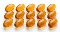 Golden omega-3 fish oil capsules arranged in rows on white background. Dietary supplement pills for health and wellness nutrition support.