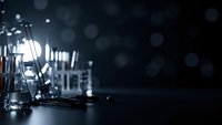 Laboratory glassware and scientific equipment on dark background with bokeh lights for research and chemistry experiments in modern lab setting.