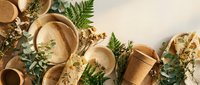 Eco-friendly biodegradable tableware with natural fern leaves on neutral background for sustainable dining and zero waste lifestyle concepts.