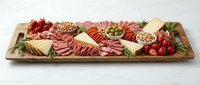 Gourmet charcuterie board with assorted meats, cheeses, nuts, olives and fresh herbs on wooden platter for entertaining and appetizer presentations.