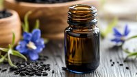 Essential oil bottle with purple flowers and seeds on rustic wooden background for aromatherapy wellness spa natural skincare organic cosmetics.