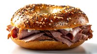 Delicious roast beef sandwich on seeded bagel with fresh ingredients isolated on white background ready for menu design and food advertising projects.