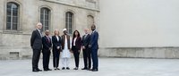 Group of five diverse business professionals standing together in formal attire outside a classical stone building, suitable for corporate, leadership, and team collaboration concepts.