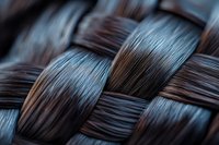Macro shot of woven dark brown and blue fibers creating an intricate basket weave pattern with selective focus and artistic blur effect. Textural background.