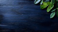 Fresh green mint leaves on dark blue wooden background with copy space for text, food photography styling for restaurant menu or cooking blog.