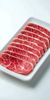 Fresh marbled beef slices arranged in row on white rectangular plate showing rich red meat texture and white fat marbling pattern for premium steak preparation.