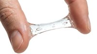 Clear gel or serum sample held between fingers, showing transparent liquid with bubbles and droplets for skincare, cosmetics, or scientific product testing.