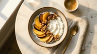 Creamy yogurt bowl topped with caramelized peach slices, granola, and honey drizzle, styled for food photography and breakfast content.