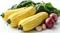 Fresh striped yellow delicata squash with red onions, garlic cloves and green swiss chard leaves on white background, ready for cooking healthy meal.