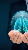 Healthcare professional in dark suit holding glowing digital lungs with medical cross symbol, representing respiratory health, pulmonary care, and medical innovation for healthcare and wellness concepts.