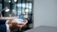 Young male professional in business suit holding smartphone with digital holographic data visualization and network connections displayed above device in modern office setting.