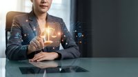Professional businesswoman touching digital justice scale hologram interface with legal technology icons in modern office environment.