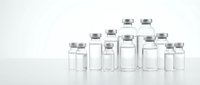 Medical glass vials with silver caps arranged in group on white background, pharmaceutical containers for vaccines, medications and laboratory samples.