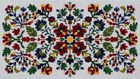 Colorful folk art embroidery pattern with floral motifs and leaves in traditional style. Symmetrical design perfect for textile decoration and crafts.