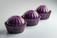Luxurious purple chocolate bonbons with ribbed metallic wrappers arranged in diagonal line on light background, elegant confectionery photography for packaging design.